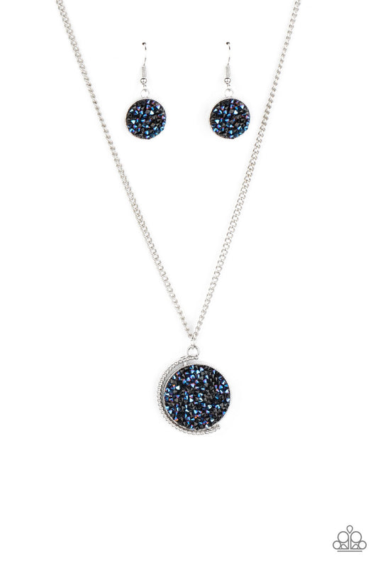 Paparazzi necklace, a smoldering collision of black and metallic blue rhinestones are encrusted across the front and back of a textured silver disc below the collar.
